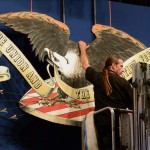 Un trabajador cuelga una representación de un águila calva el escenario preparado para el debate presidencial estadounidense 2012. EFE/Archivo
