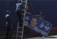 Un grupo de trabajadores instala un afiche de los candidatos por el Partido Nacional en un poste de luz en Tegucigalpa. EFE