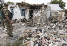 Un militar observa los escombros de un edificio tras un bombardeo en territorio controlado por el ejército ucraniano, en el pueblo de Novotroitsk, Ucrania, el pasado miércoles. EFE