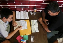 Vista de dos personas llenando un formulario en el Servicio de Ciudadanía e Inmigración (USCIS). EFE/Archivo
