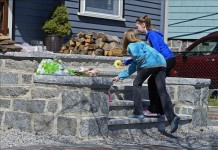 Dos niñas colocan flores en el portal de la casa de Martin Richards, el niño de ocho años asesinado en una de las dos explosiones de ayer durante la maratón de Boston. EFE
