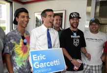 El candidato demócrata a la alcaldía de Los Ángeles Eric Garcetti (2 izq.) posa con un afiche de su campaña política después de almorzar con estudiantes de la escuela mecánica de aviación Van Nuys ayer martes 21 de mayo. EFE