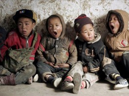 Niños del grupo minoritario de la etnia Yi se sientan en el suelo de su aula durante una clase, porque su empobrecida escuela no puede permitirse suficientes sillas y mesas, en la Prefectura rural Autónoma de Liangshan Yi, en la provincia de Sichuan, China. EFE/Archivo