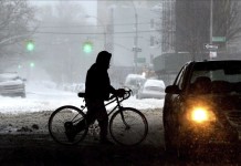 Un hombre camina sosteniendo su bicicleta por las calles nevadas en el distrito de Brooklyn en Nueva York (Estados Unidos) hoy, viernes 3 de enero de 2014. EFE
