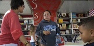 Fotografía del 2 de septiembre de 2015, de niños de la Escuela Elemental de Veteranos que observan libros, durante la visita de la librería rodante "Book Truck" en Chula Vista (CA, EE.UU.). EFE