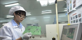 Una mujer trabaja en una línea de producción en una fábrica chino-japonesa de componentes electrónicos para automóviles en Wuhan, en la provincia de Hubei, en China. EFE/Archivo